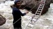Members of Nanda Devi Expedition crossing fierce stream on makeshift bridges