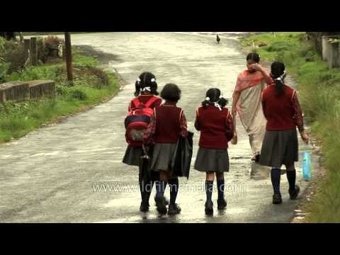 Children walk home on rain drenched roads in Cherapunji