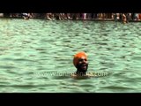 Devotee takes a dip in the pool of holy nectar at Gurudwara Takht Sri Kesgarh Sahib.