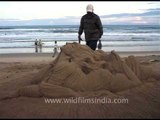 Sand sculpture : creating a mythical creature using one's hand, Puri Beach