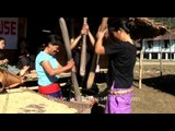 Women pound grain with wooden pestle and mortar in Arunachal