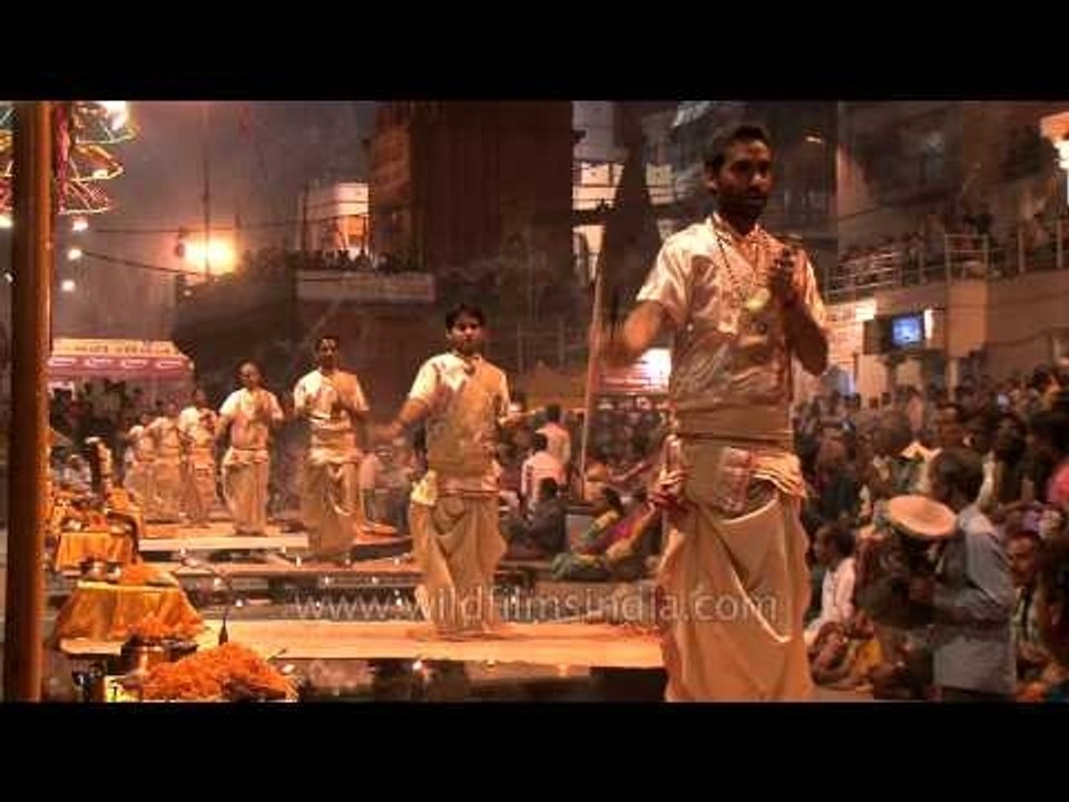 Young pundits draped in satin robes performing Ganga Aarti in Varanasi