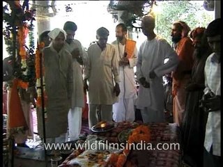 Devotees offering money and clothes on mausoleum of Hindu Saint