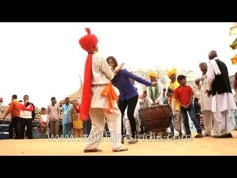 Girl performing dance with folk dancer at Surajkund mela