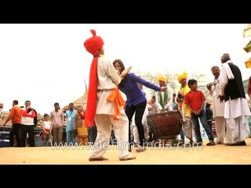 Girl performing dance with folk dancer at Surajkund mela