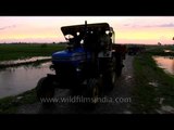 Farmers return from work riding tractors & trucks in Uttar Pradesh