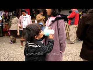 Kid drinking fruit juice at Hornbill festival, Nagaland