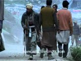 Pilgrims walking with visible Amarnath base-camp in background, J&K