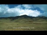 Clouds moving fast in a time lapse casting shadow on Dzukou Valley
