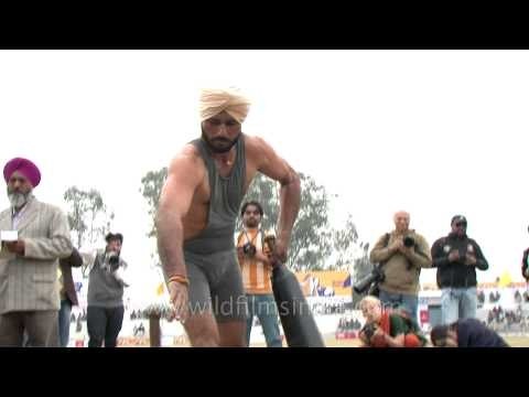 Indian super man lifting heavy weight in rural olympics