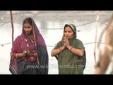 Hindu women perform rituals on the bank of the river Yamuna during Chhatt puja