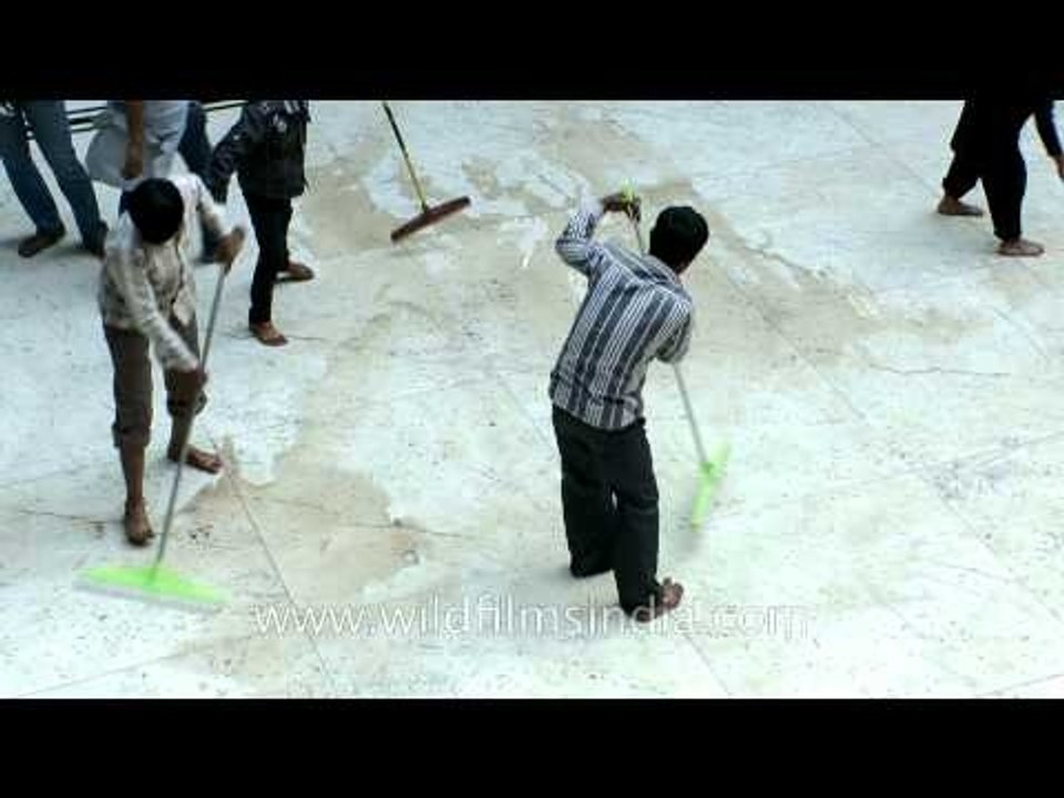 People cleaning floor for blood shed on Muharram