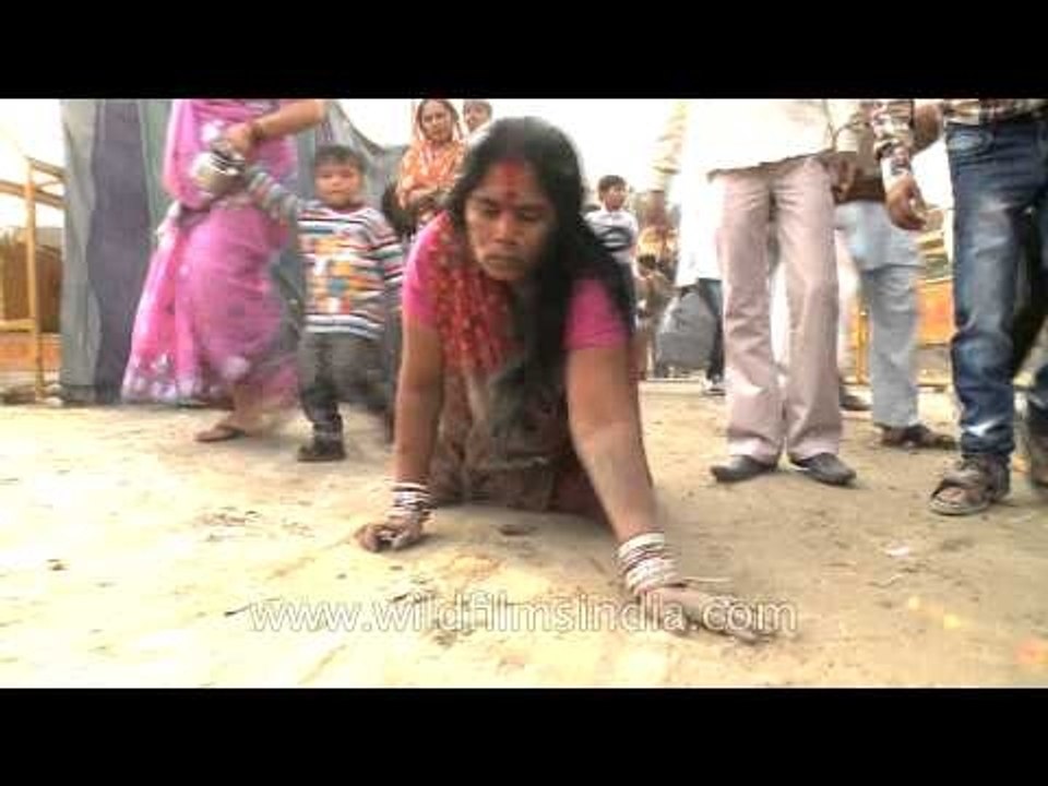 Female devotee crawling towards ghat during Chatt Puja
