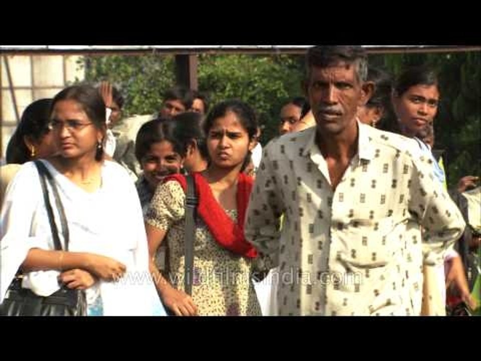 People standing on the bus stand and waiting for their buses