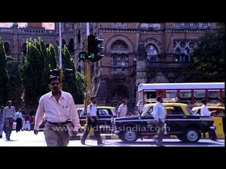 Man crossing a busy road of Mumbai in front of Brihanmumbai Municipal Corporation