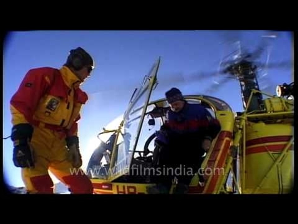 Helicopter dropping off skiers at an elevated point in Himalayas