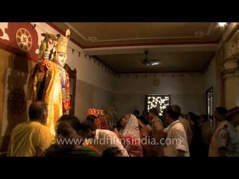 Shri Krishna statue with devotees bowing down at the Birla temple