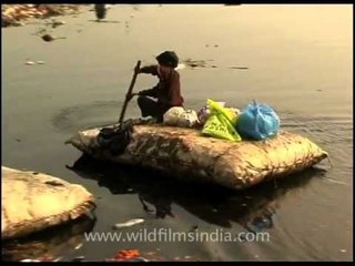 Rag picker rows on a raft made of sacking and polystyrene, Yamuna!