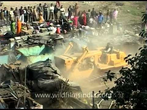 Demolishing the box and board houses of the slum-dwellers