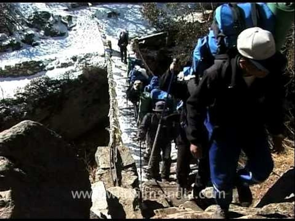 Everest trekkers crossing a weak bridge