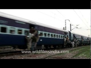 People hanging out of a crowded train in India!