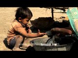 A child helps his mother, Gujarat