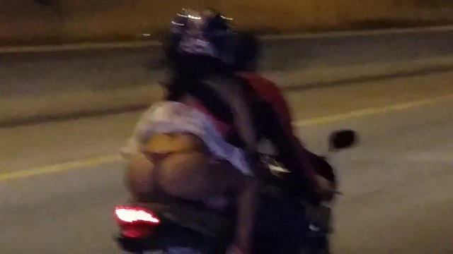 Une jolie fille à l'arrière d'une moto dévoile ses atouts!