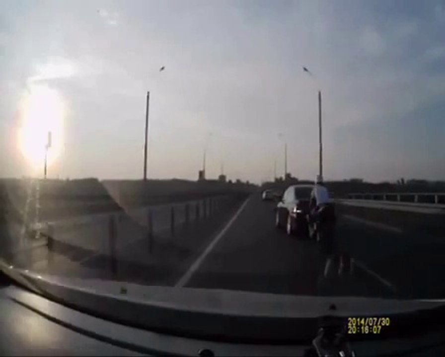 Un motard percute une voiture et fini debout sur le toit! Du jamais vu...