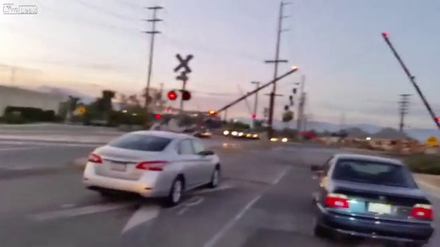 Une voiture avec le klaxon d'un train fait des blagues au passage à niveau.