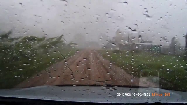 Tornado destroying a house while the owner is trying to park his car