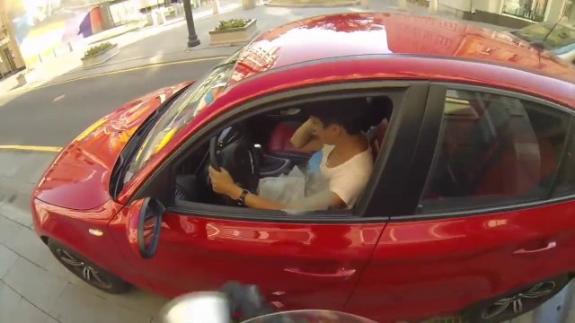 Un motard écolo balance un cendrier dans la voiture d'un pollueur!