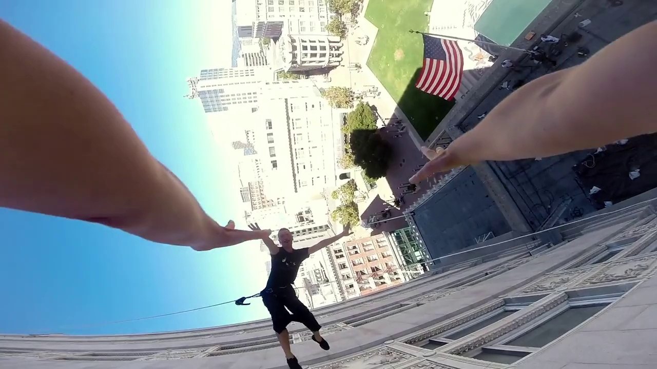 2 danseurs marchent et dansent sur les murs du City Hall