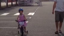Jeanne fait du vélo avec les roulettes