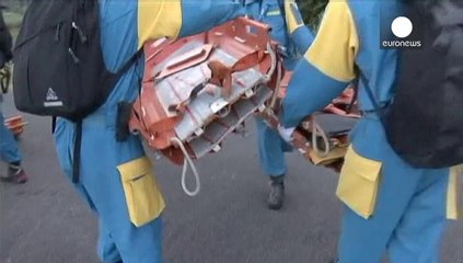 Rescue workers bring down bodies from Japanese volcano