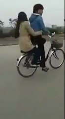 little boy and girl trying one wheeling on bicycle.