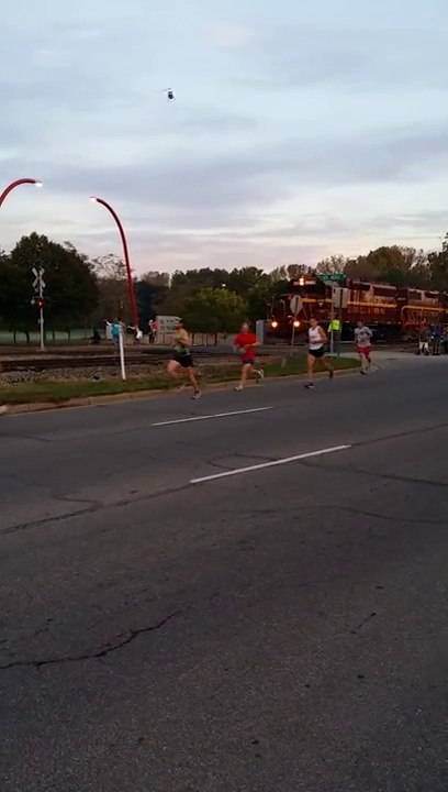Un train coupe la route des coureurs d'un Marathon - Mill Race Marathon