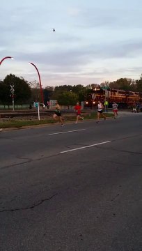 Un train coupe la route des coureurs d'un Marathon - Mill Race Marathon