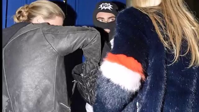 Cara Delevingne covers up in kooky balaclava and skeleton trousers to dine out with sister Poppy