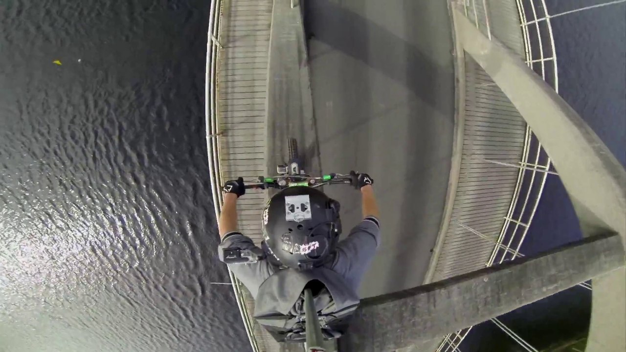 Un rider fait du vélo sur le sommet d'un pont!