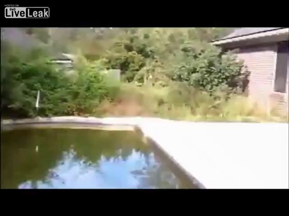 Un abruti tente de sauter au dessus d'une piscine