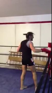 Un vieil homme donne une leçon de boxe à un jeune homme