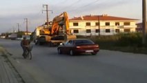 Une pelleteuse pousse un camion en panne d'essence