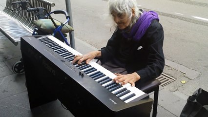 Une vieille dame joue au piano dans la rue pour gagner sa vie