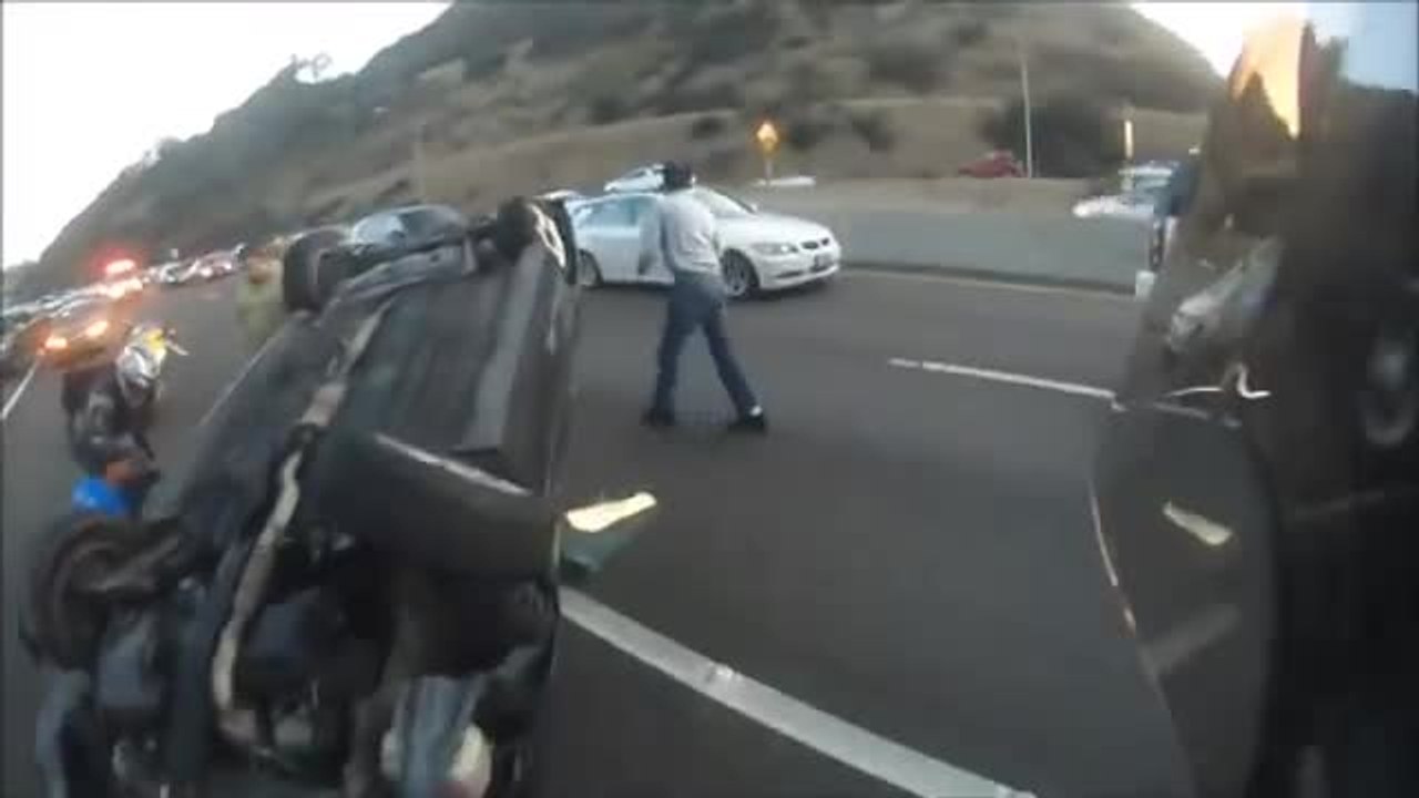 Un motard aide une fille coincée sous une voiture