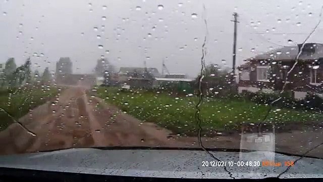 Un homme sort sa voiture du garage juste avant qu'une tornade arrive