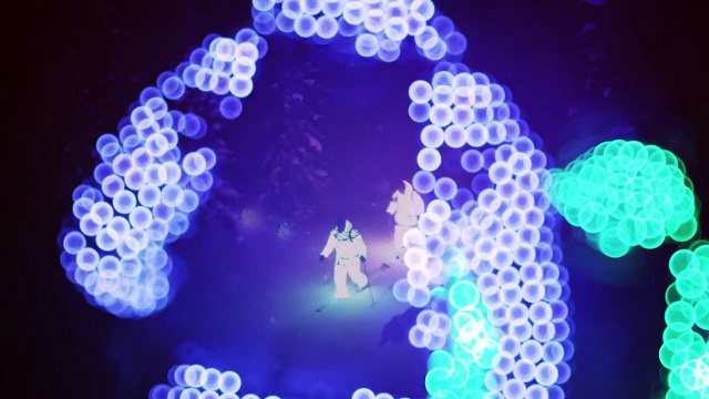 Skieurs en combinaisons lumineuses pendant la nuit