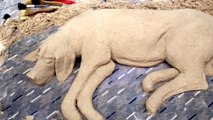Street artists sculpts realistic sand 