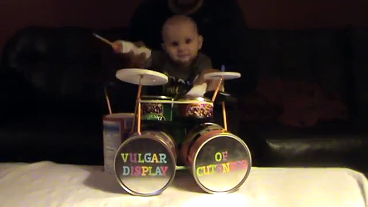 Un bébé joue de la batterie