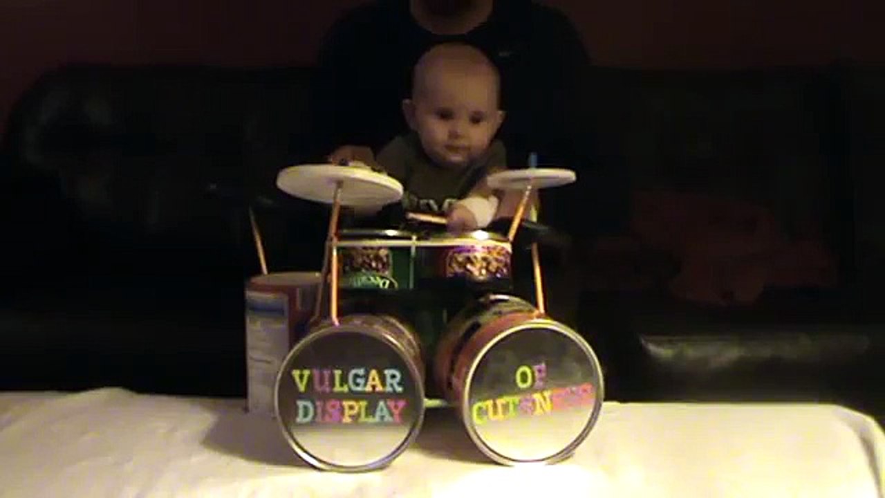 Un bébé joue de la batterie