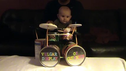 Un bébé joue de la batterie
